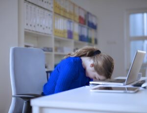 A female graduate student has her head down on her laptop because of bad scientific leadership